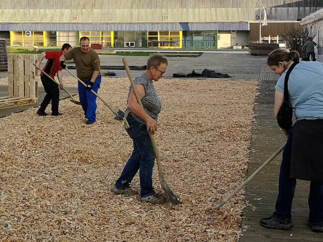 Rund um die Openair Bühne des Musiktag Ruswil werden Holzschnitzel verlegt.